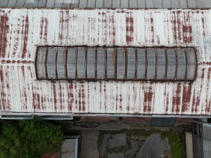 Drone view of ageing industrial roof with corrosion